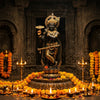 Krishna murti holding the Sudarshan Chakra on his finger in a mandir niche with diyas