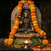 Handcrafted Shiva murti with trishul in a mandir niche with diya and marigolds