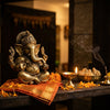 Handcrafted Ganesha murti at a home entrance with diya and modaks
