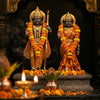 Handcrafted Sita and Rama murtis in a mandir niche with marigold garlands and a diya